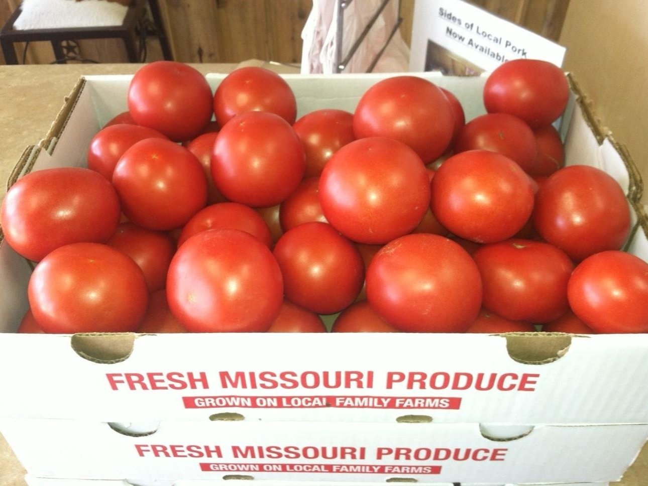 10271201_618860728205545_2230086861160284591_o Fresh red tomatoes displayed in a box labeled "Fresh Missouri Produce, Grown on Local Family Farms," highlighting locally sourced agricultural products.